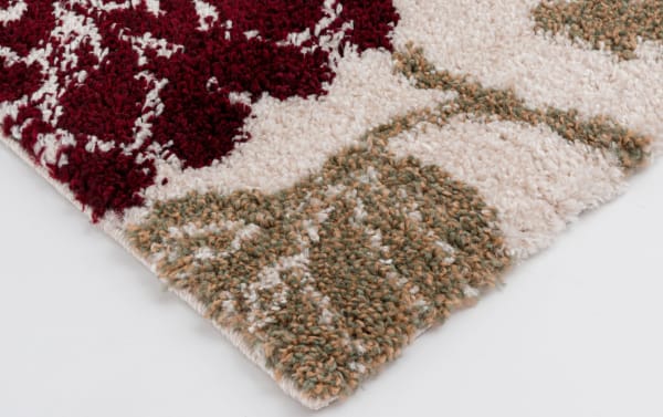 Corner view of Carn 5' x 7' Ivory Floral Rug with a plush polypropylene pile, featuring a multicolored transitional floral pattern in ivory, red, and muted green tones.