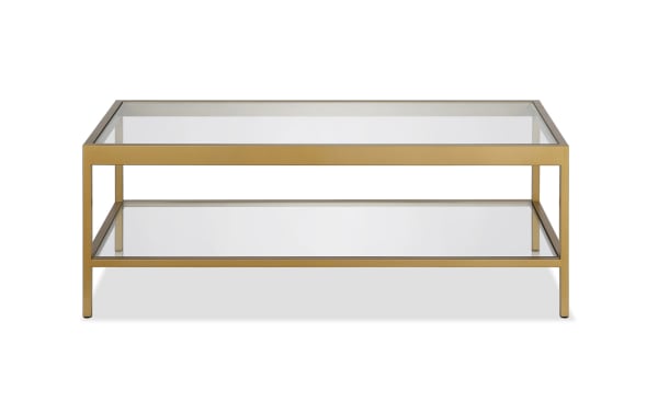 Alexa Brass Coffee Table from the Alexa collection features a contemporary hand-crafted brass steel frame, tempered glass top, and lower glass shelf for stylish storage.