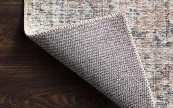 Corner view of the Candis 8' x 10' Blush Oriental Rug showing blush, gray, ivory, and charcoal tones in a traditional old-world pattern, made of durable 100% polyester fabric with a woven texture.