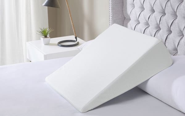 White memory foam wedge pillow with soft knit cover, designed for neck and leg elevation, transitional style for enhanced comfort and support.