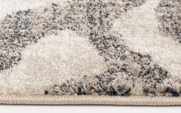 Close-up of the Hadid 5' x 7' Gray Animal Print Rug showing soft, dense polypropylene fibers in gray and cream with a modern transitional animal print pattern.