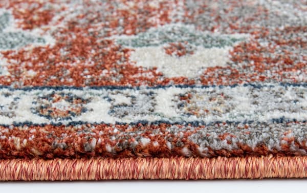 Close-up of the Tamin 6' x 9' Multi Oriental Rug edge, showing dense polypropylene fibers in blue, red, cream, orange, and gray with a transitional design and durable machine-made weave.