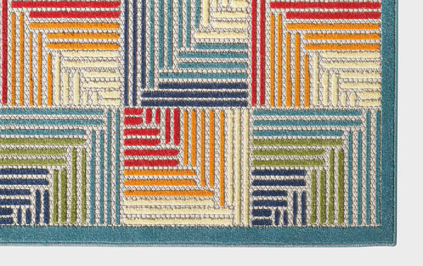 Tae 5' x 7' multi geometric indoor/outdoor rug in multicolored blue, cream, orange, red, green, and purple polypropylene fibers with a transitional abstract design.