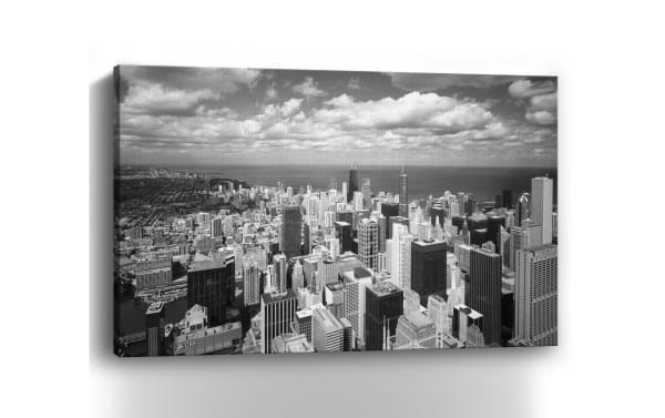 Chicago Lakeshore Canvas Wall Art features a black-and-white aerial view of Chicago's skyline printed on durable polyester fabric, hand-stretched over solid pine. This transitional style wall decor highlights iconic skyscrapers and Lake Michigan, perfect for adding urban sophistication to living rooms, bedrooms, or entryways.
