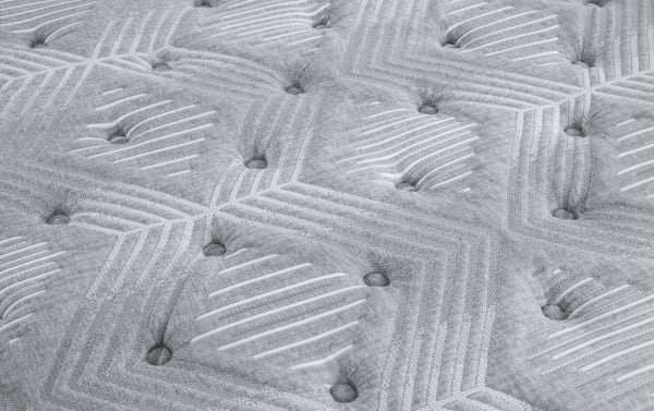 Quilted gray fabric surface of Affinity Hybrid 12'' Twin Plush Mattress with tufted buttons and geometric stitching, featuring breathable knit cover and memory foam upholstery.