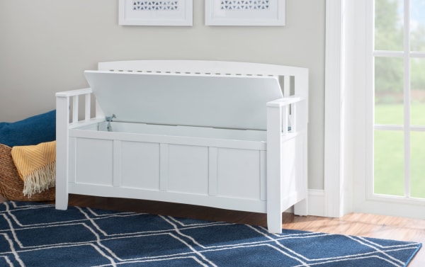 Sentney White Storage Bench in transitional style, made of rubberwood solids and MDF, features a flip-top lid with no-slam hardware for hidden storage. The white bench includes slat-back design and armrests, ideal for entryways or bedrooms, offering extra seating and storage space.