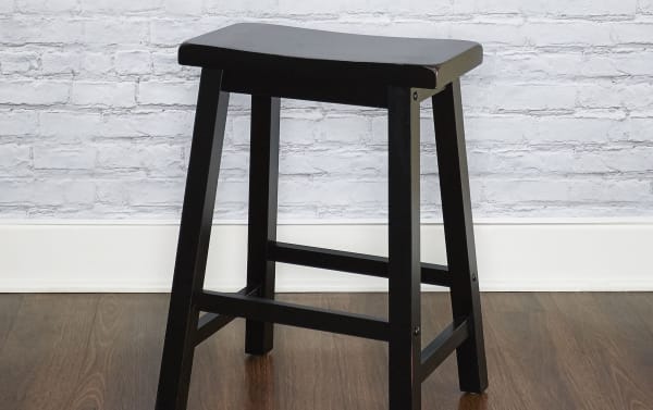 Ruiseal black solid wood backless counter height stool with saddle-shaped seat, tapered legs, and transitional style in rubberwood solids.