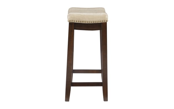 Backless Cielo Beige faux leather counter height stool with deep brown rubberwood frame, antique brass nailhead trim, and transitional style seat.