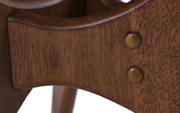 Close-up of Derby Pecan Solid Wood End Table’s mid-century modern cross base with birch veneer and natural elm finish, showcasing wood grain and rounded joinery details.