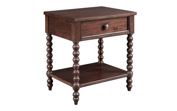Padme Brown Nightstand with Drawer in traditional style, made of acacia veneers with a natural brown finish, featuring turned solid wood legs, a single drawer with metal knob, and a lower shelf for storage.