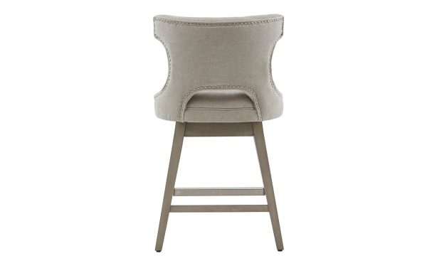 Kaya light gray upholstered swivel counter stool with solid wood legs, transitional style, pewter nailhead trim, and open back design.