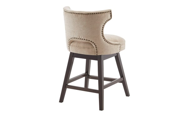 Kaya Beige Upholstered Counter Height Swivel Stool with solid wood legs, beige fabric, pewter nail head trim, and transitional style.