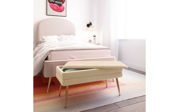 Contemporary Astrid Cream Storage Bench with velvet upholstery, channel-tufted top, and polished gold stainless steel legs, ideal for bedroom storage.