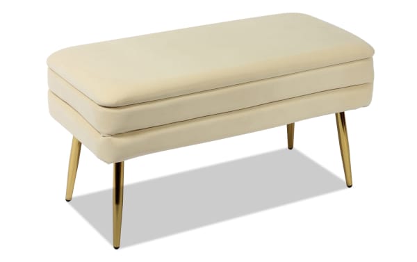 Astrid Cream Storage Bench with plush velvet upholstery, sleek polished gold stainless steel legs, and contemporary channel-tufted design.