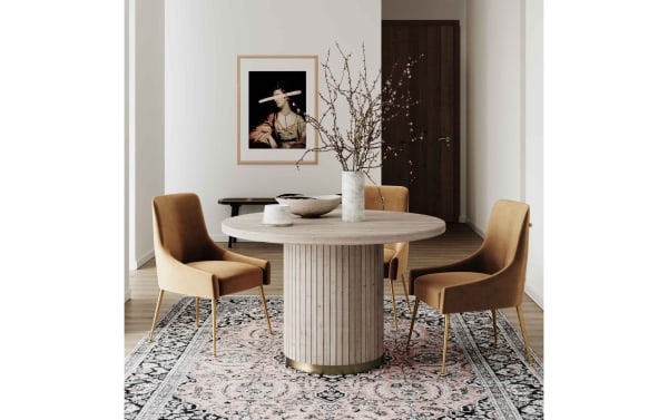Contemporary Giselle II Cognac solid back dining chairs in brown velvet with gold stainless steel legs around a round wooden table on a patterned rug.