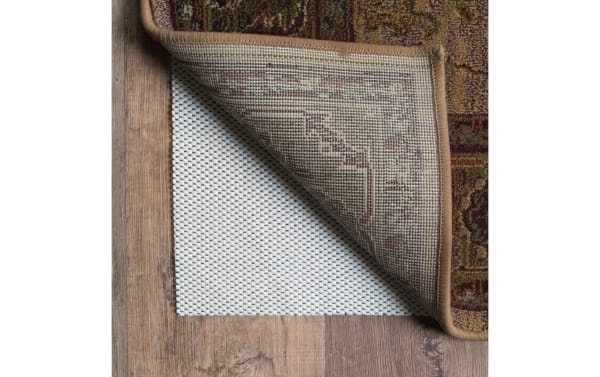 Beige Bob's 9' x 12' Magic Rug Pad under a transitional style fabric polyester rug, featuring a non-slip textured surface to protect wood floors and extend rug life.