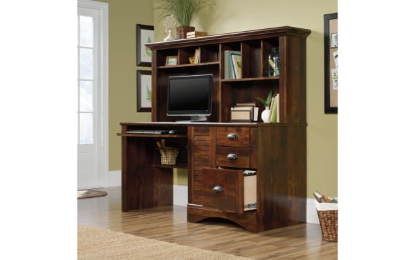Transitional Cove Cherry 3 Drawer Desk with Curado cherry finish, particle board, metal hardware, louvered door, cubbies, and slide-out keyboard shelf for organized workspace.