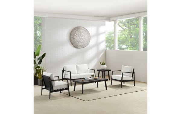 Transitional Suvi Outdoor white aluminum chair with black powder-coated frame, white acrylic cushions, and rust-resistant steel legs for outdoor use.