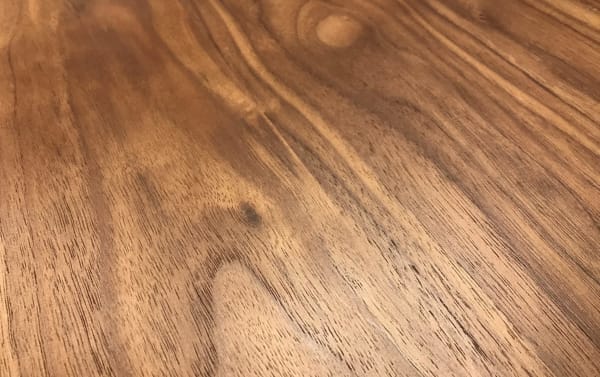 Maderna Brown Coffee Table with walnut veneer surface, mid-century modern curved top, and slanted legs in industrial style.
