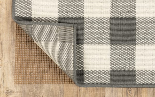 Brown outdoor rug pad with non-slip grid backing, made of weather-resistant polyester fabric, designed for 9' x 12' rugs, transitional style.