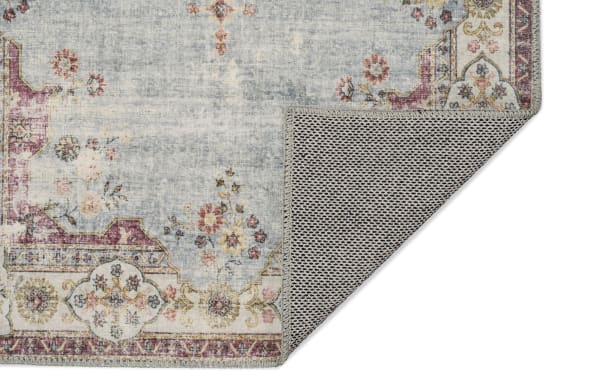 Kinsley 5' x 7' light blue traditional washable rug with floral pattern, polyester fabric, non-slip backing, and stain-resistant finish.