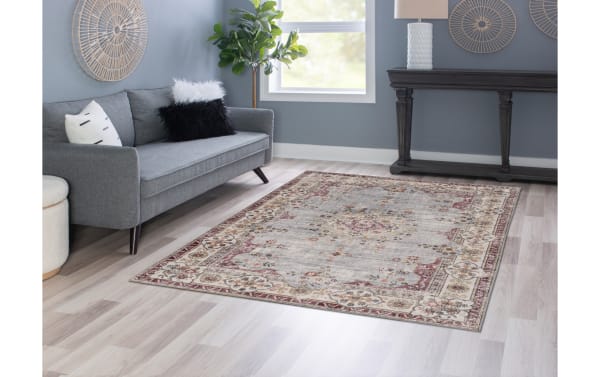 Light blue Kinsley 5' x 7' traditional washable rug with floral border, stain-resistant polyester fabric, and non-slip backing for high-traffic areas.