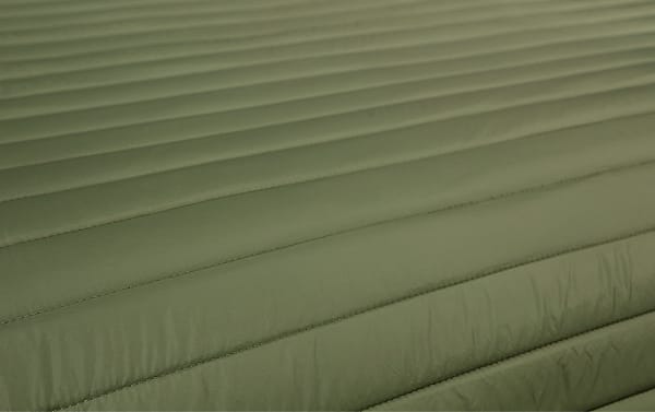Solid green quilted polyester fabric of the Griffin Twin Green Solid 2 Piece Comforter Set, featuring a transitional style with horizontal stitching for a plush, puffer jacket-inspired look.