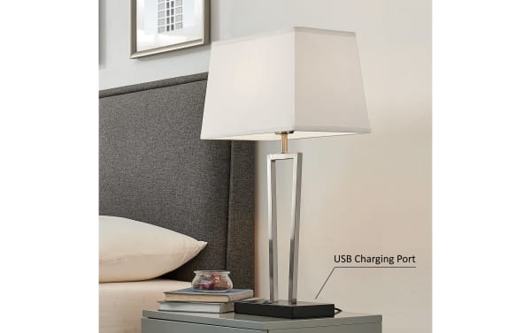 Contemporary Stella brushed nickel table lamp with geometric metal base, white rectangular fabric shade, and USB charging port on black plastic base.