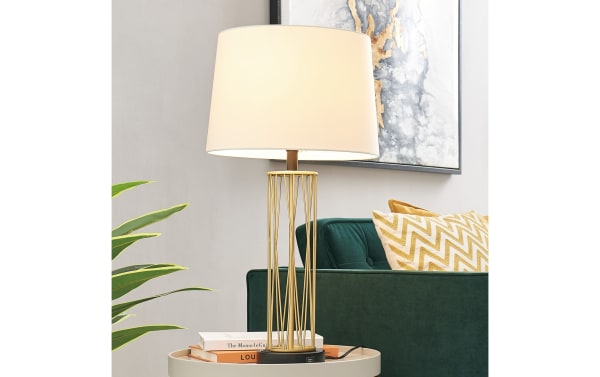 Contemporary Dallas Gold Table Lamp with white fabric shade, gold metal geometric base, and USB charging ports on round plastic base.