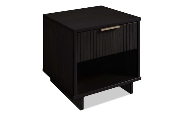 Ascias Black Nightstand with Drawer in solid wood, contemporary style with vertical ribbed front, soft-close drawer, open bottom shelf, black UV finish, and sleek metal handle.