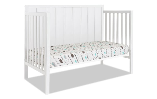 Ollie White 4-in-1 Convertible Crib in white pine wood with farmhouse style slat design, transitional look, and patterned mattress included.