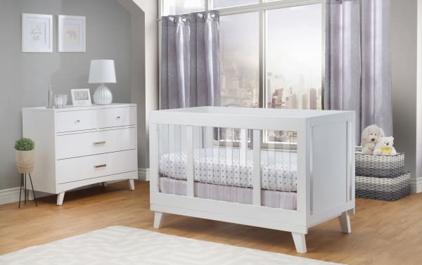 Contemporary Olive White Crib with clear acrylic slats, solid pine wood panels, adjustable mattress heights, and modern white finish for nurseries.