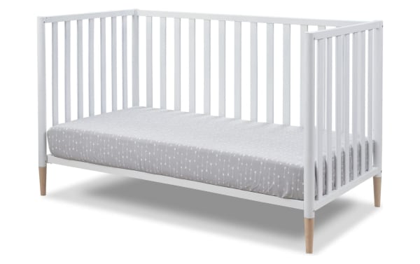 Jasper White 3-in-1 Convertible Crib in solid wood with a contemporary Scandi-inspired design, white finish, and removable natural wood legs.