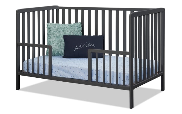 Avery/Primrose Navy Toddler Conversion Rail in dark wood, transitional style, with partial side rails and blue polka dot bedding, from Primrose Avery collection.