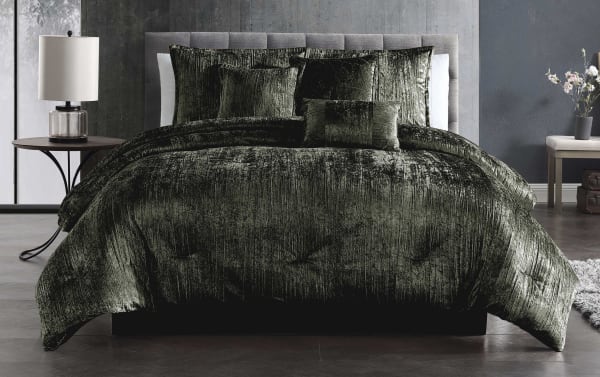 Luxurious dark green crushed velvet comforter set on a modern bed with matching pillows, showcasing soft texture and elegant bedroom decor.
