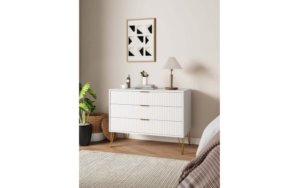 Delilah White 3 Drawer Dresser with vertical ribbed MDF fronts, gold metal splayed legs, and soft-close drawers in contemporary style.