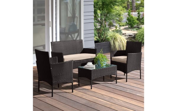 Callum 4 Piece Black Rattan Outdoor Conversation Set with beige cushions, featuring PE rattan, powder-coated steel frame, and glass-top coffee table. Contemporary patio furniture includes two armchairs, loveseat, and table, designed for durability and weather resistance.