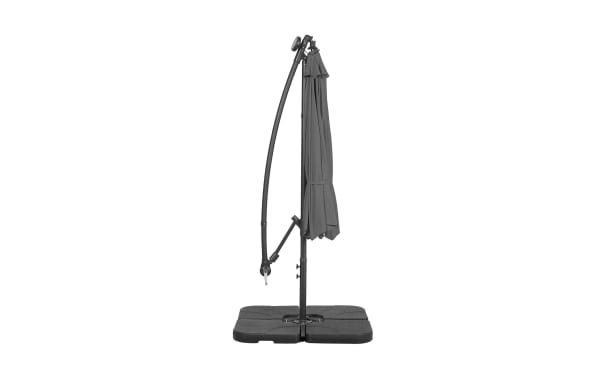 Dark gray cantilever patio umbrella with a curved metal frame and four black weighted base plates for stability, designed for outdoor shade.