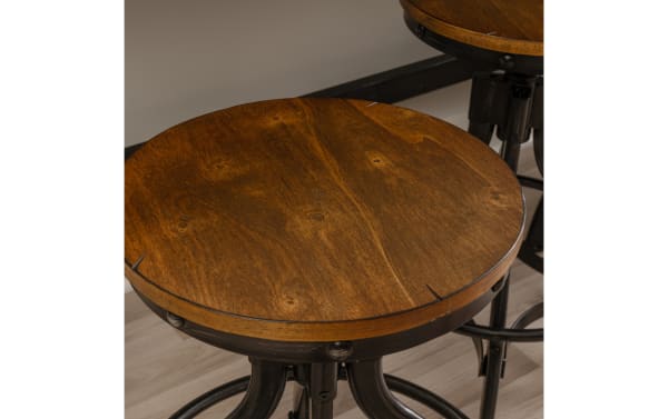 Hadley Brown Backless Adjustable Stool with round wooden MDF seat, industrial steel frame, rivet details, and round footrest in hand-brushed finish.