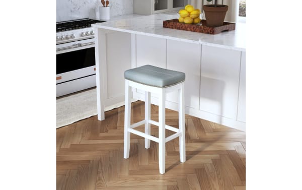 Ryann Light Gray Faux Leather Backless Bar Height Stool with padded polyester fabric seat, nailhead trim, and sturdy white rubberwood legs, contemporary style.