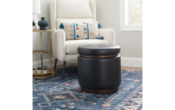 Blaze Black & Brown Faux Leather Storage Ottoman in traditional style with black faux leather upholstery, wood base, and cushioned top for storage, seating, or footrest.