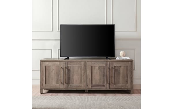 Zion 68'' Gray Storage TV Stand in transitional style with sturdy MDF frame, four paneled doors, brass handles, and ample enclosed shelving for TVs up to 65".