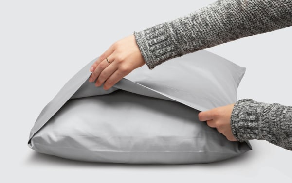 Hands holding a gray MyBob's Queen Cozy Cotton pillowcase made of breathable, soft 100% long-staple cotton with traditional style and antimicrobial fabric.