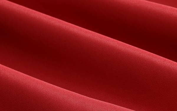 Rich red polyester fabric with a smooth, tightly woven texture featured on the Delany Red 9' Twin Outdoor Umbrella, showcasing durable, transitional-style outdoor upholstery.