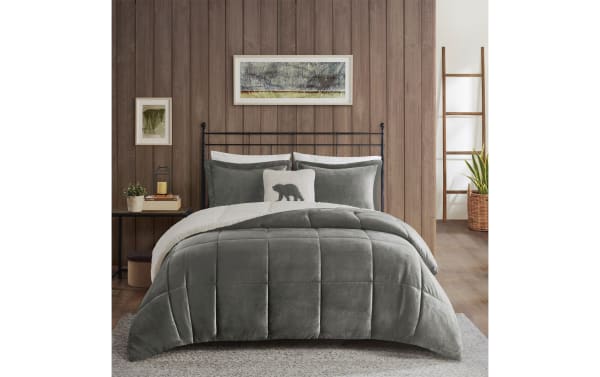 Gray velvet Sherpa-lined comforter set on black metal bed frame with wooden wall, ladder, and potted plants in cozy bedroom setting.
