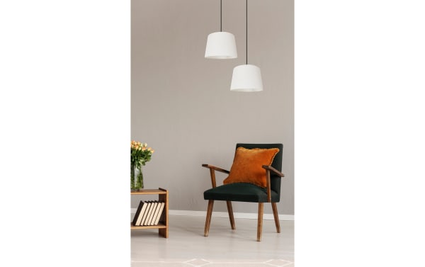 Mid-century modern Beatrice Antique Pewter Pendant lights in gray linen fabric with steel frame, illuminating a cozy living room with wooden chair and table.