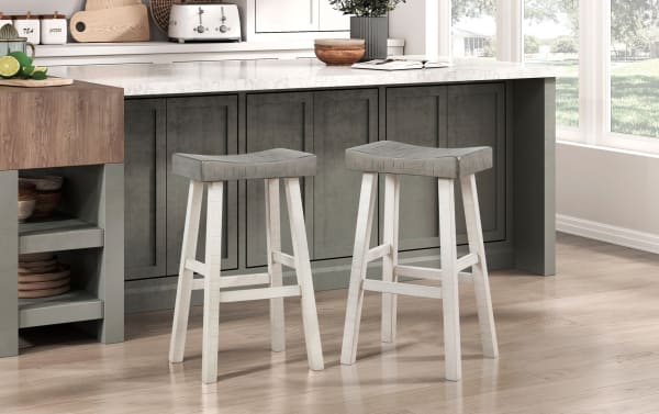 Set of 2 Alicia White & Gray Solid Wood Backless Bar Height Stools with rustic saddle-style gray seats and white rubberwood legs for kitchen islands.