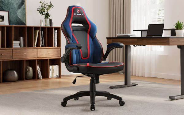 Ergonomic Eureka gaming chair in blue and black with red trim, adjustable armrests, high backrest, and cushioned seat in modern office setting.