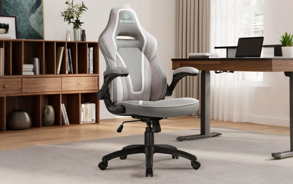 Eureka ergonomic gaming chair in light gray and white with adjustable armrests and high backrest, placed in a modern office setting.