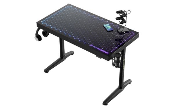 Orbit Black Glass Top Gaming Desk by Eureka, transitional style with black tempered glass surface and powder-coated metal frame, featuring RGB lighting effects, headphone hook, cup holder, controller rack, and phone stand for gaming and streaming setups.